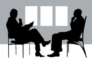 Two people seated having a discussion.